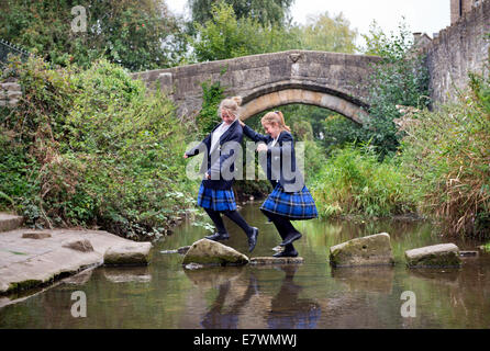 Ragazze imbarco a re la Scuola di attraversare il fiume Brue nel Somerset villaggio di Bruton REGNO UNITO Foto Stock