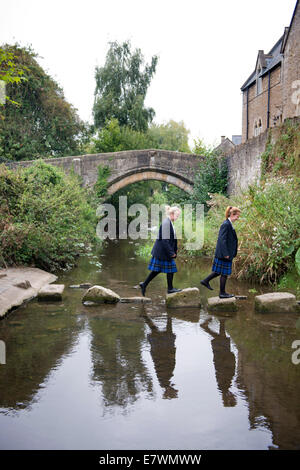 Ragazze imbarco a re la Scuola di attraversare il fiume Brue nel Somerset villaggio di Bruton REGNO UNITO Foto Stock