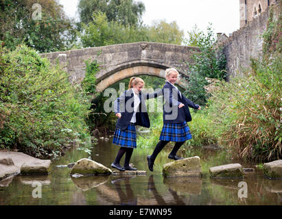 Ragazze imbarco a re la Scuola di attraversare il fiume Brue nel Somerset villaggio di Bruton REGNO UNITO Foto Stock