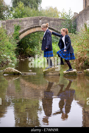 Ragazze imbarco a re la Scuola di attraversare il fiume Brue nel Somerset villaggio di Bruton REGNO UNITO Foto Stock