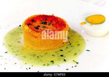 Pomodoro di Pachino torta con salsa di uova su un letto di erbe aromatiche fresche e cospargere con basilico Foto Stock