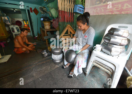 Bangkok, Tailandia - 26 Marzo 2014: una donna fanno Baht, l'Alms vaso utilizzato dai monaci di ricevere donazioni di alimenti in Bangkok. Foto Stock