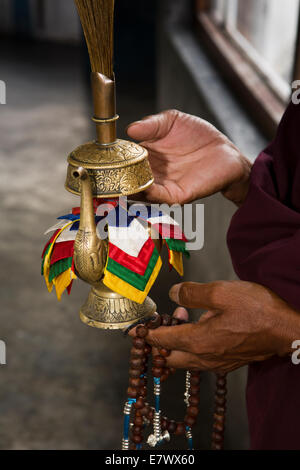 Il Bhutan orientale, Trashigang, Rangjung Woesel Choeling monastero mani di uomo azienda brocca rituale Foto Stock