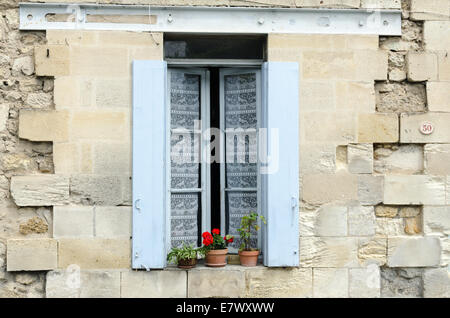Tipica finestra francese con persiane colorate su una vecchia casa di pietra in St Emilion, Francia Foto Stock
