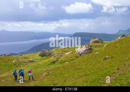 Gli escursionisti a piedi a Storr con la Quiraing e Loch Leathan nella distanza, Isola di Skye in Scozia. Foto Stock