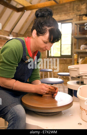 Donna dimostrando claybowl facendo sul lancio della ruota in corrispondenza di un patrimonio e di dimostrazione al giorno ad un ceramiche locali, farnham, Regno Unito. Foto Stock