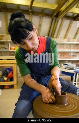 Donna che dimostra claybowl fare sulla ruota di lancio in un giorno di storia e dimostrazione in una ceramica locale, Farnham, Surrey, Regno Unito. Foto Stock