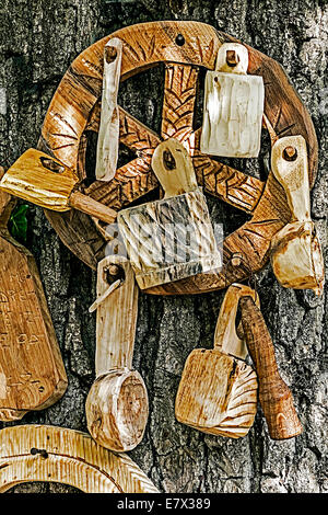 Il rumeno di oggetti tradizionali scolpito in legno e esposto sulla corteccia di un albero. Foto Stock