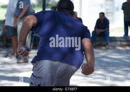 L'uomo tiene il bocconcino di metallo durante la partita di Petanque in Provenza, Francia Foto Stock