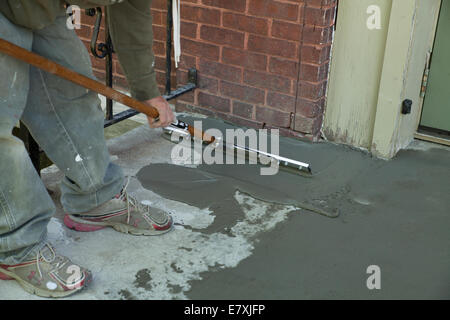 Workman smussa un rivestimento skim di cemento su una vecchia scalinata. Foto Stock