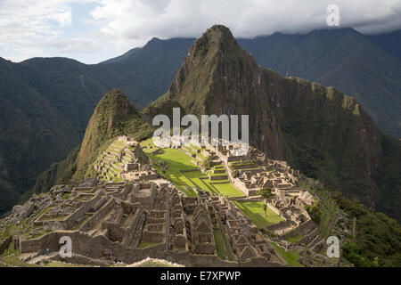 Panoramica di Machu Picchu con il sole pomeridiano evidenziando gli edifici e le verdi terrazze. Foto Stock