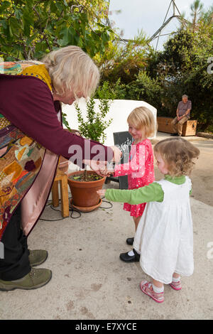 Storyteller nel carattere al Progetto Eden in Cornovaglia soddisfa due sorelle dopo una storia da un gruppo di entusiasti giovani bambini / ragazzi. Regno Unito Foto Stock