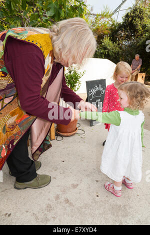 Storyteller nel carattere al Progetto Eden in Cornovaglia soddisfa due sorelle dopo una storia da un gruppo di entusiasti giovani bambini / ragazzi. Regno Unito Foto Stock