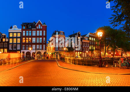 Notte Vista sulla città di Amsterdam canal, il ponte e le case tipiche, biciclette, Holland, Paesi Bassi. Lunga esposizione fotografia. Foto Stock