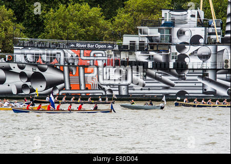 Barche di passare il dispositivo HMS Presidente che è stato verniciato in 'Dazzle' camuffamento di vernice in commemorazione di WW1, il grande fiume gara, London's River Marathon (noto anche come il Regno Unito barca tradizionale campionato) - Un 21,6 miglia gara in barca lungo il fiume Tamigi da Docklands di Londra al prosciutto in Surrey. Esso attrae oltre 300 equipaggi provenienti da tutto il mondo e fa appello ad ogni livello del concorrente di coloro che godono di divertimento, Fancy Dress e carità di acrobazie, a gravi sportivi. Il fiume Tamigi, Londra, 27 settembre 2014. Foto Stock