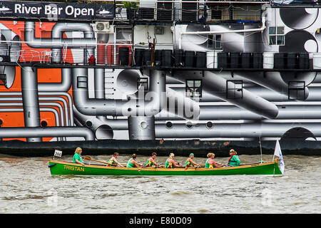 Barche di passare il dispositivo HMS Presidente che è stato verniciato in 'Dazzle' camuffamento di vernice in commemorazione di WW1, il grande fiume gara, London's River Marathon (noto anche come il Regno Unito barca tradizionale campionato) - Un 21,6 miglia gara in barca lungo il fiume Tamigi da Docklands di Londra al prosciutto in Surrey. Esso attrae oltre 300 equipaggi provenienti da tutto il mondo e fa appello ad ogni livello del concorrente di coloro che godono di divertimento, Fancy Dress e carità di acrobazie, a gravi sportivi. Il fiume Tamigi, Londra, 27 settembre 2014. Foto Stock