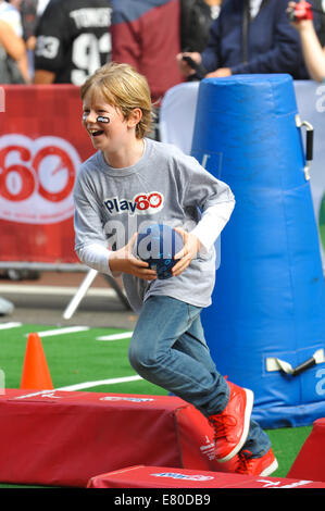 Regent Street, Londra, Regno Unito. Il 27 settembre 2014. I bambini godono di divertimento e giochi su una miniatura di calcio. NFL su Regent Street una tenda-raiser al primo di questo anno di tre NFL Serie Internazionale giochi. Credito: Matteo Chattle/Alamy Live News Foto Stock