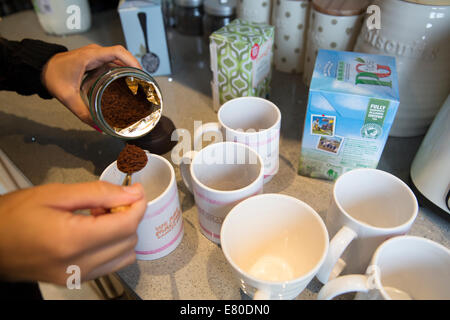 Donna che fa il caffè istantaneo in cucina Foto Stock