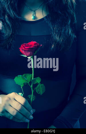 Dettaglio della donna che mantiene una rosa rossa Foto Stock