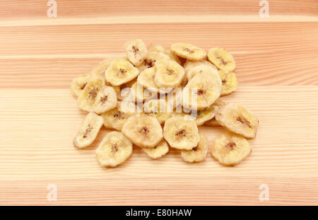 Pila di Banane essiccate chip su un legno sfondo della granella Foto Stock