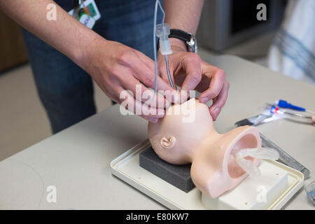 Calgary, Alberta, Canada, 27 settembre, 2014. Il dott. Michael Assaad dimostra l'intubazione computerizzata manichino pediatrico nel nuovo centro KidSIM all'Alberta ospedale per bambini durante le porte aperte YYC. La struttura all'avanguardia, la più grande simulazione pediatrica centro in Canada, fornisce i medici e le famiglie dei pazienti con la simulazione di una esperienza clinica quanto più vicino possibile a situazioni della vita reale. Foto Stock