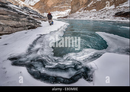 Facchini è tirando il trekking di bagagli sul fiume Zanskar durante Chadar trek Foto Stock