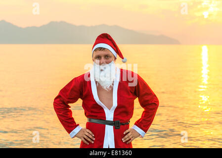 Un giovane uomo in un Babbo Natale che pongono in costume Foto Stock