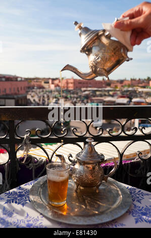 Verticale fino in prossimità della tradizionale tè alla menta versata da una altezza in piccoli bicchieri che si affaccia su Piazza Jemaa El Fnaa di Marrakech Foto Stock