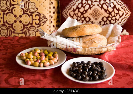 Chiudere orizzontale di tradizionale pane marocchino, khobz, servita con verde e olive nere in Marrakech. Foto Stock