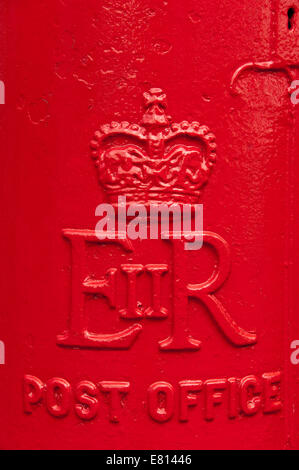 Verticale di chiusura del embosed ER II iniziali sulla parte anteriore di un colore rosso brillante postbox. Foto Stock