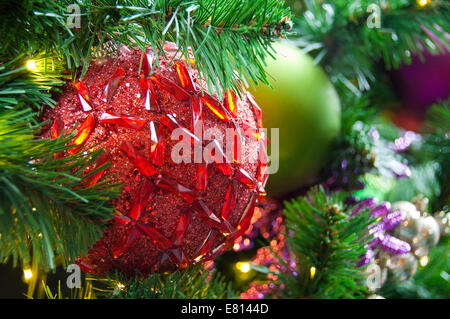 Chiudere orizzontale di vivacemente colorati ornamentali decorazioni di Natale sulla reale pino. Foto Stock