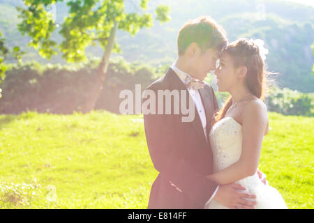 Sposa e lo sposo che circonda da naturale golden luce solare Foto Stock