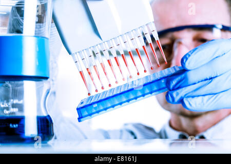 Scienziato multipipette utilizza durante la ricerca di DNA Foto Stock