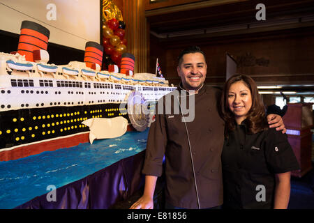 Long Beach, Stati Uniti d'America. Settembre 26, 2014 - Lo Chef Jose Barajas e il suo assistente Olivia ha lavorato tutta la notte per completare la 15', 600 lb torta di compleanno per l'ottantesimo anniversario del lancio del RMS Queen Mary presso la celebrazione dell anniversario a bordo della nave a Long Beach, CA. La torta è stato costruito da 30 24'x18' foglio bianco torte, utilizzando 100 libbre di farina, 100 libbre di crema di burro e 200 libbre di modellazione e di cioccolato fondente. Credito: Kayte Deioma/Alamy Live News Foto Stock