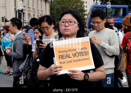 Una giovane donna da Hong Kong detiene una lettura della targhetta ' Hong Kong vuole real voti" Foto Stock