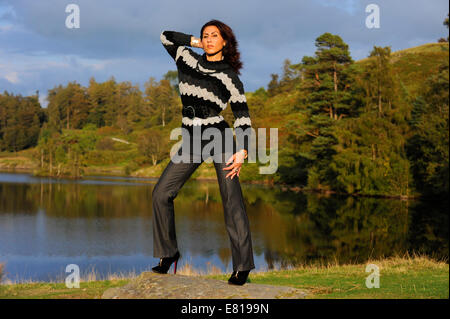 Una giovane donna autunno di modellazione moda in posizione nel distretto del Lago Foto Stock