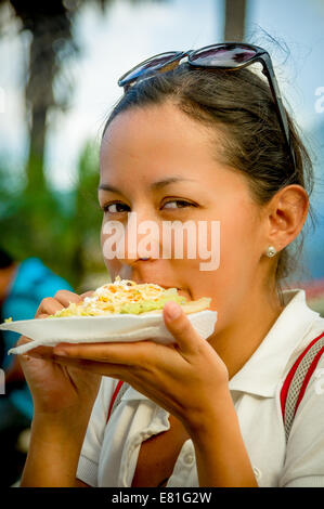 Giovane e bella ragazza a mangiare una tostada soft taco Foto Stock