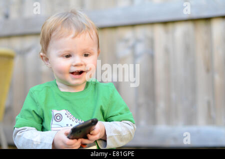 Due anni di vecchio ragazzo giocando con Mobile Smart Phone Foto Stock