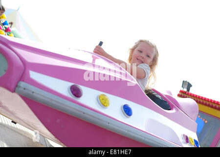 Bambina di cinque anni su Fairground Ride Foto Stock