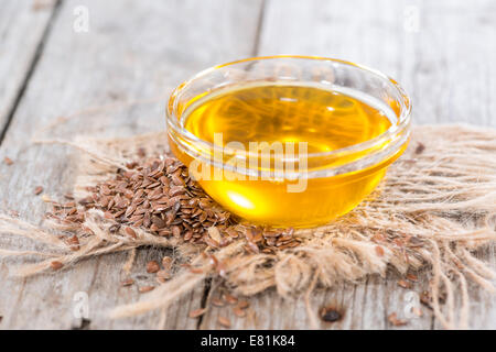 Porzione di golden olio di semi di lino con alcuni semi intorno Foto Stock