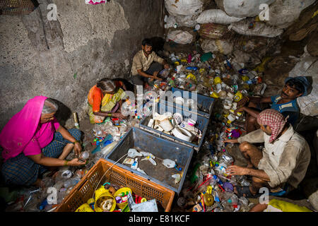 I lavoratori di smistamento di immondizia di plastica per il riciclaggio, Dharavi Slum, Mumbai, Maharashtra, India Foto Stock