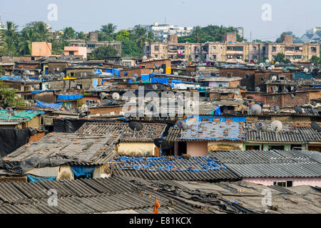 Una delle baraccopoli con case fatte dal ferro corrugato fogli, con piatti TV sui tetti, Mumbai, Maharashtra, India Foto Stock
