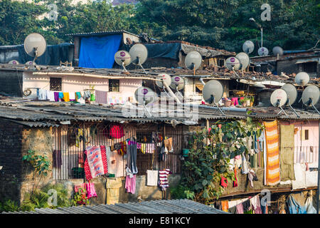 Una delle baraccopoli con case fatte dal ferro corrugato fogli, con piatti TV sui tetti, Mumbai, Maharashtra, India Foto Stock