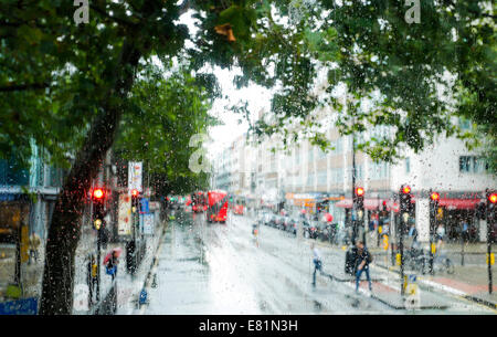 London street scene attraverso la pioggia-bus imbevuto di windows, London, England, Regno Unito Foto Stock