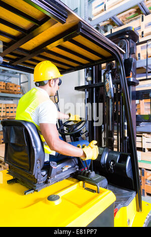 Asian carrello elevatore a forche di sollevamento driver pallet nel magazzino di stoccaggio Foto Stock