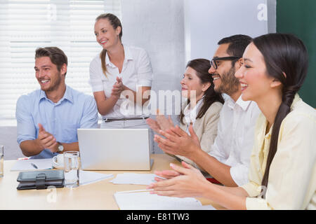 Sorridente la gente di affari battendo le mani durante una riunione Foto Stock