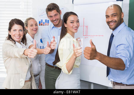 Sorridente team business gesticolando Thumbs up in riunione Foto Stock