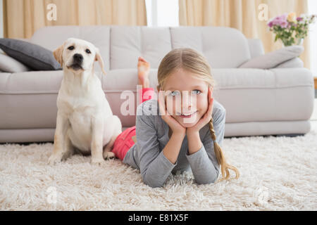 Incantevole piccola ragazza con il suo cucciolo su rug Foto Stock