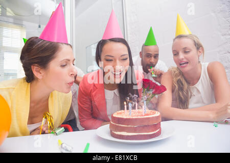 Imprenditrice soffiando le candeline sulla sua torta di compleanno Foto Stock