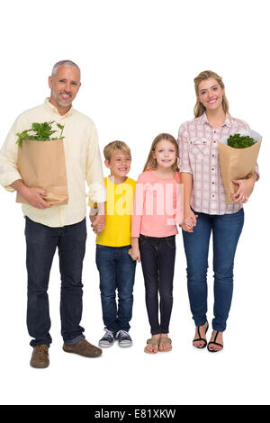 La famiglia felice con sacchetti di negozi di generi alimentari Foto Stock